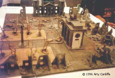 This is an overview of downtown Berlin c.1945 after, Bomber Command and the 8th Air force have done some re-modelling. As modelled by Chris Leach. You are looking at the park to the left and, the Brandenburg Gate at the centre, with the Reichstag in the background. Knocked out German vehicles litter the streets. The Soviet Shock troops are massing in the burnt out buildings in the foreground.
